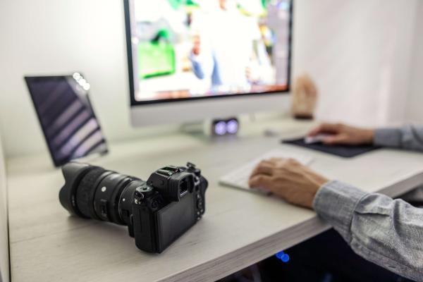 Muž upravující fotky na počítači vyfocené přes zrcadlovku.
